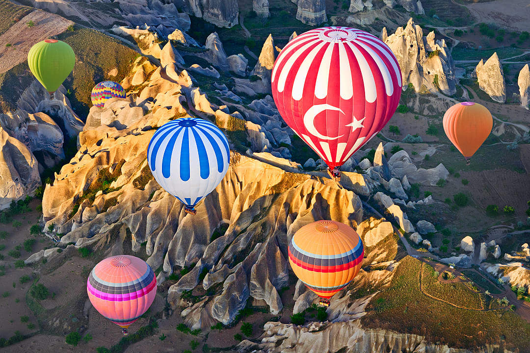 Hot air balloons over mountain landscape in Cappadocia, Turkey