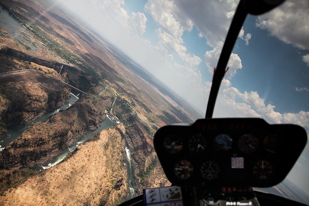 A helicopter soars over Victoria Falls, revealing breathtaking aerial views.