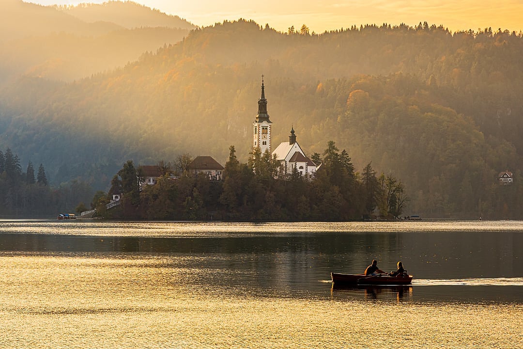 Couple boating at sunrise on Lake Bled, Slovenia
