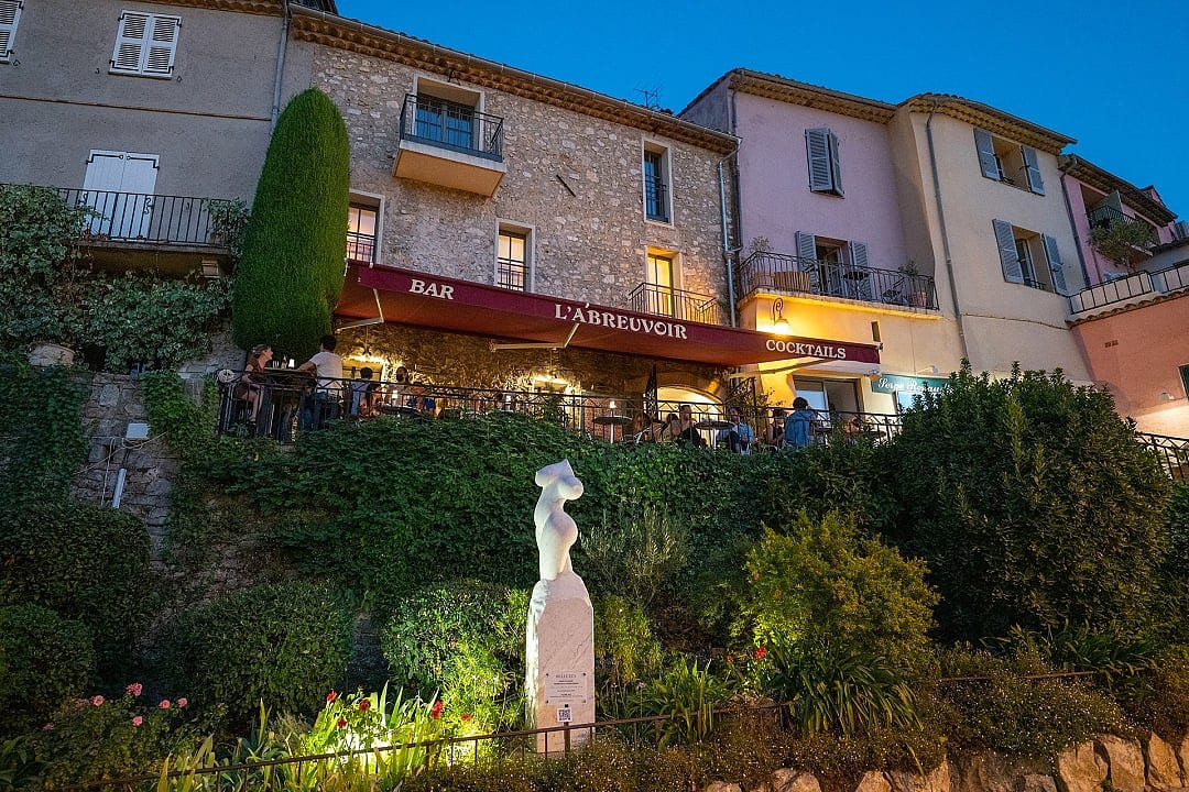 Cozy evening in charming Mougins village, surrounded by greenery, lit terraces, and art
