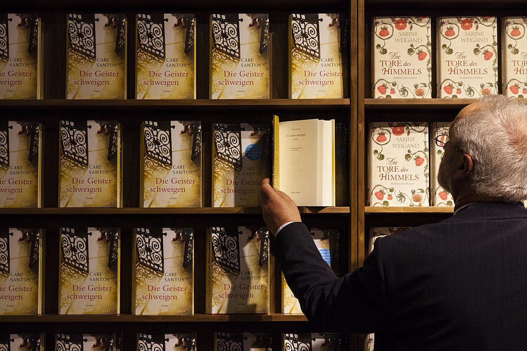 Visitor with a wall of books at the Frankfurter Buchmesse in Germany