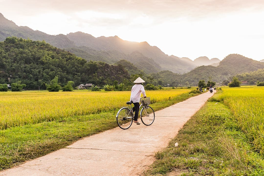 Local riding a bike in the hillsides of Mai Chau, Vietnam.