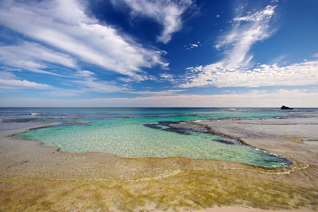 Crystal-clear lagoon waters sparkle under the wide blue skies of Rottnest Island.
