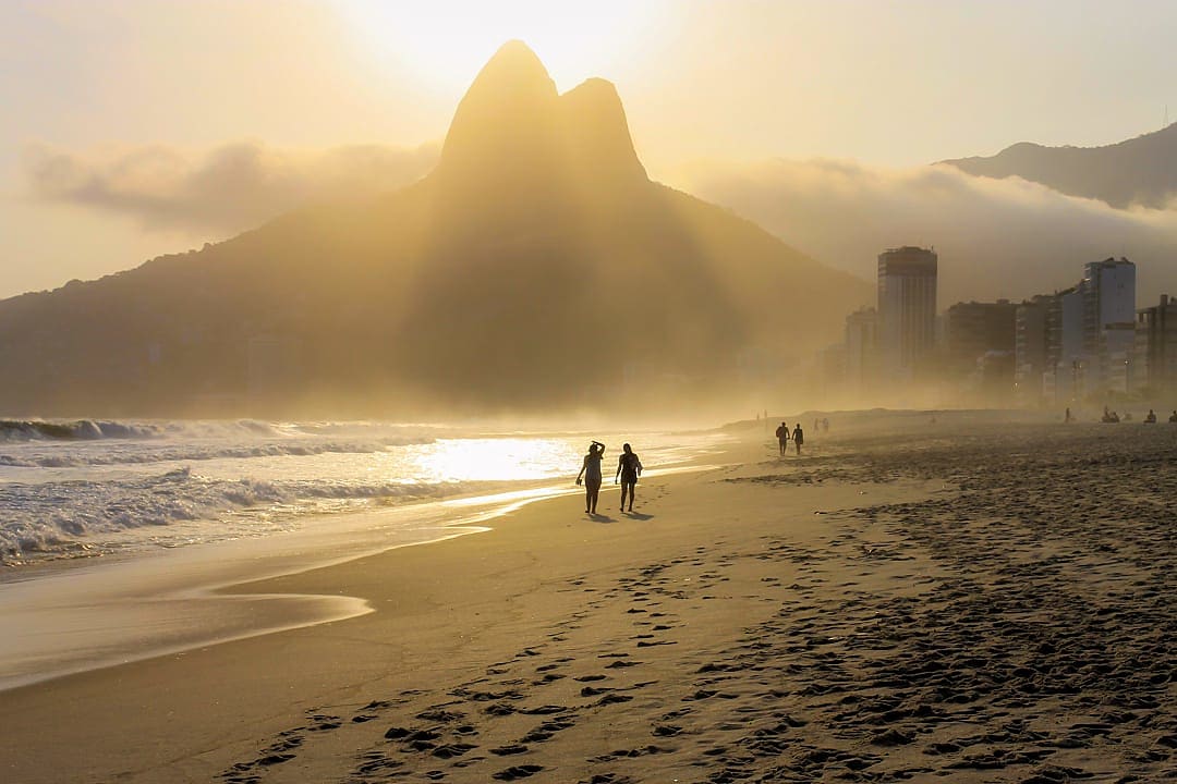 Couple walking on Ipanema Beach at sunset.