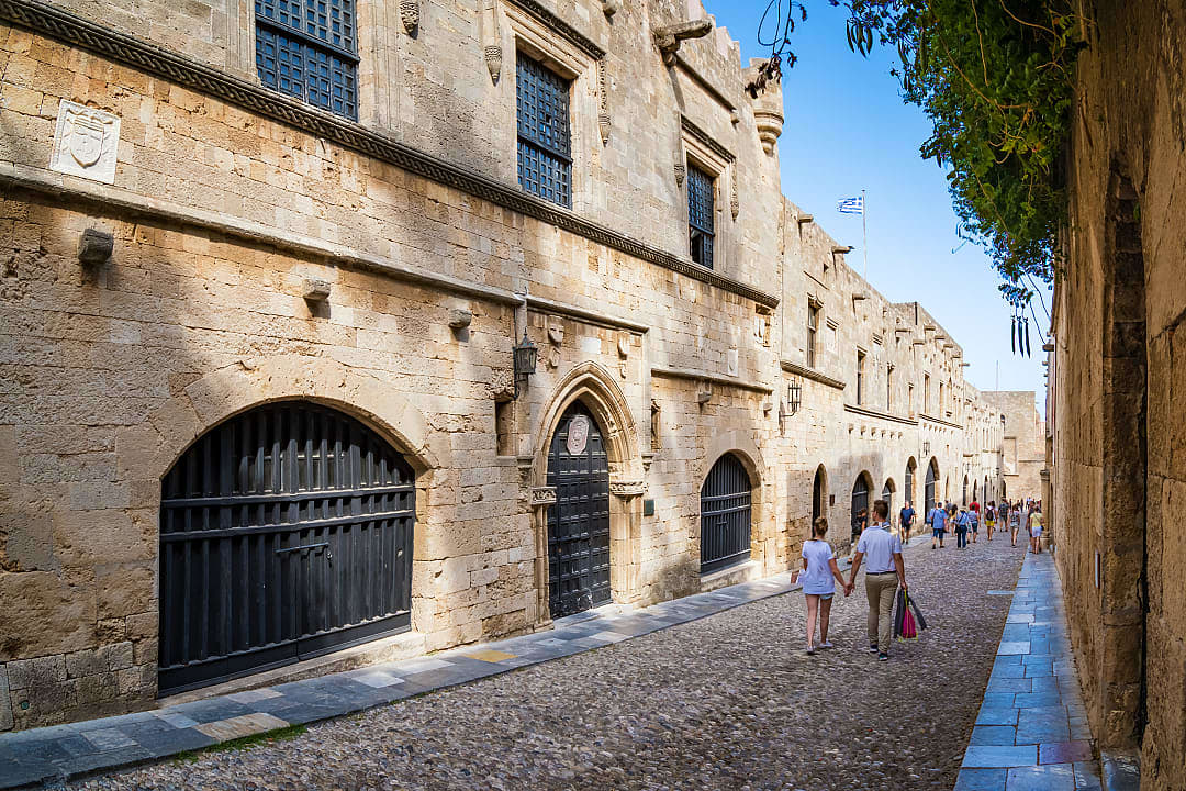 Couple walking down a cobblestone street in Rhodes, Greece