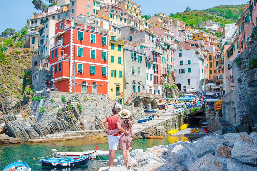Couple enjoying the beach in Riomaggiore, Cinque Terre, Italy.