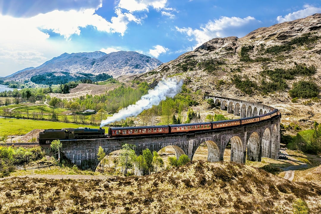 Glenfinnan railway viaduct with the Jacobite steam train in Scottish Highlands