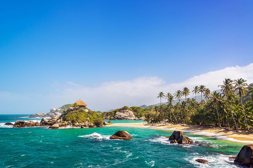 Palm trees and blue Caribbean water on the beach of San Juan del Guia in Tayrona National Park, Colombia