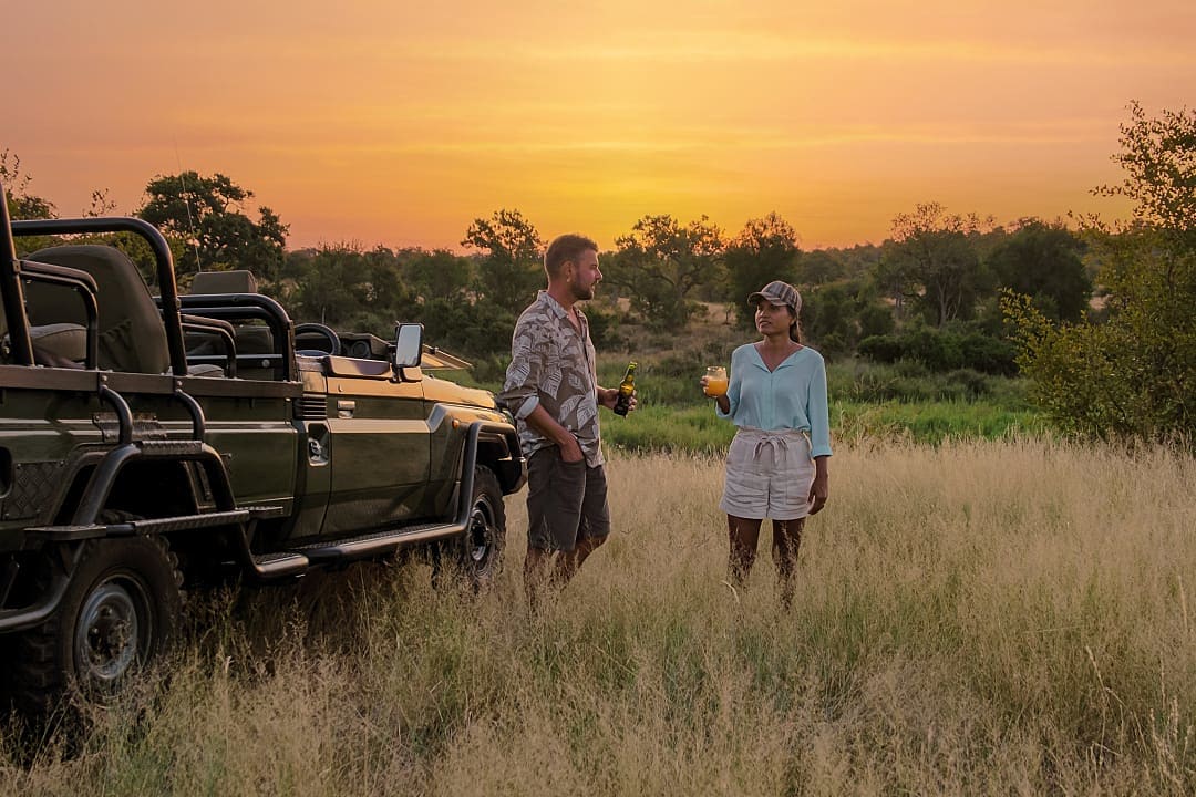 A couple enjoying sundowners during their African safari.