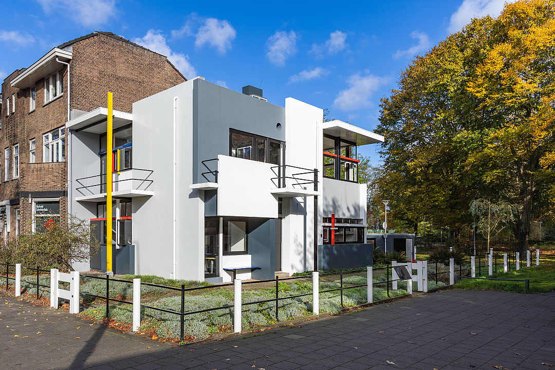 The geometric exterior of the Rietveld Schröder House featuring primary colors and intersecting vertical and horizontal lines.