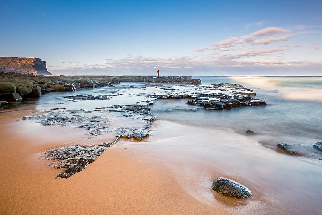 Person looking out at the sea, on a beach in Sydney.