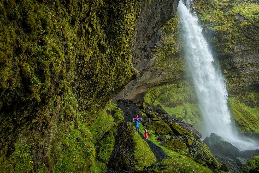 Father and daughters hiking the path to Kvernufoss in Iceland