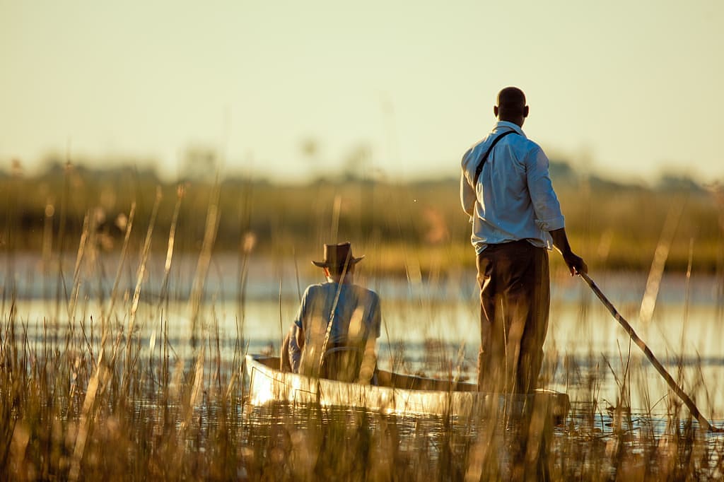 Early morning mokoro boat safari in the Okavango Delta, Botswana