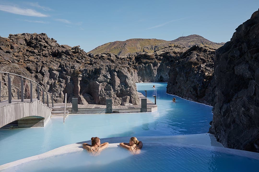 Two women relaxing in natural thermal waters of the Retreat at the Blue Lagoon in Iceland