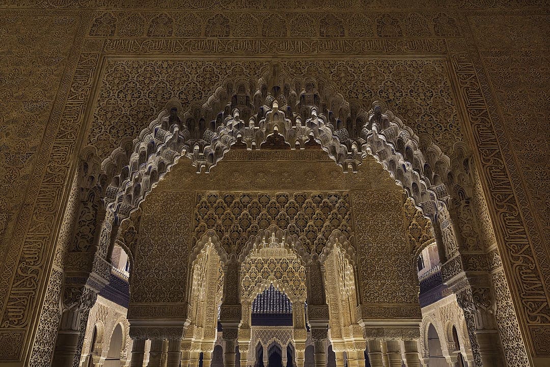 Intricate Moorish architecture inside the Alhambra in Granada, Spain, showcasing ornate arches and carvings