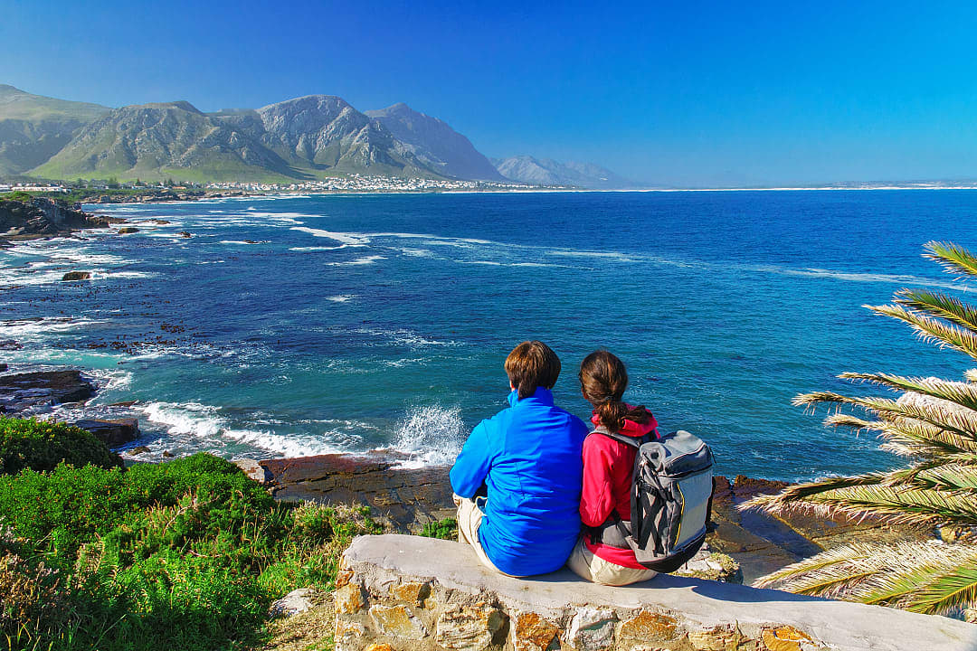 Couple looking out to the bay from Gearing's Point in Hermanus, South Africa