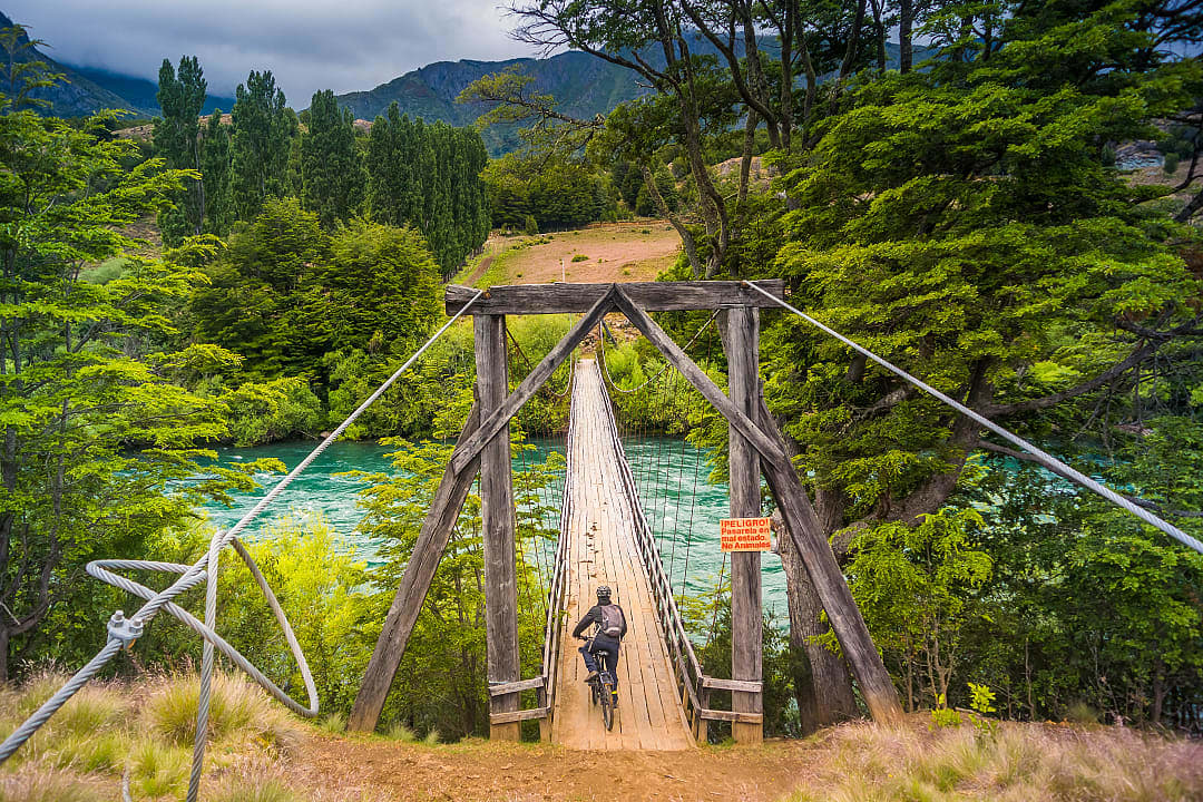 Biker on wooden bridge crossing the Futaleufu river in Northern Patagonia
