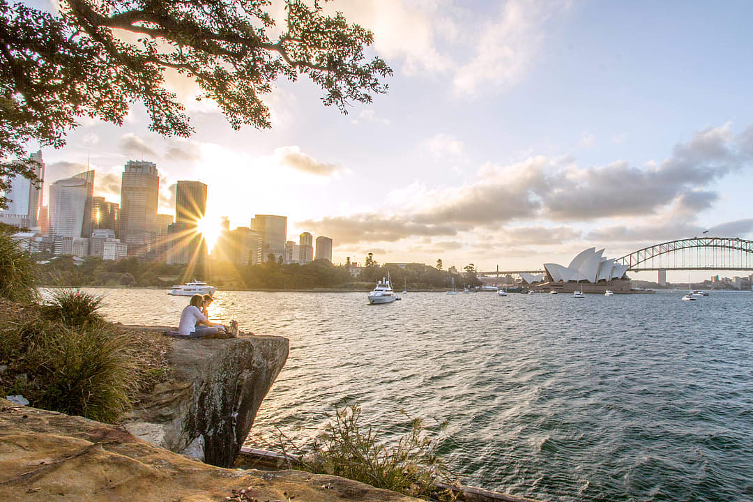 A couple enjoying the view of the Sydney Harbor during sunset.