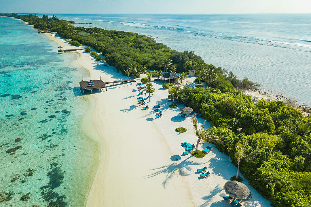 Tropical beach resort in the Maldives, featuring white sands and turquoise waters.