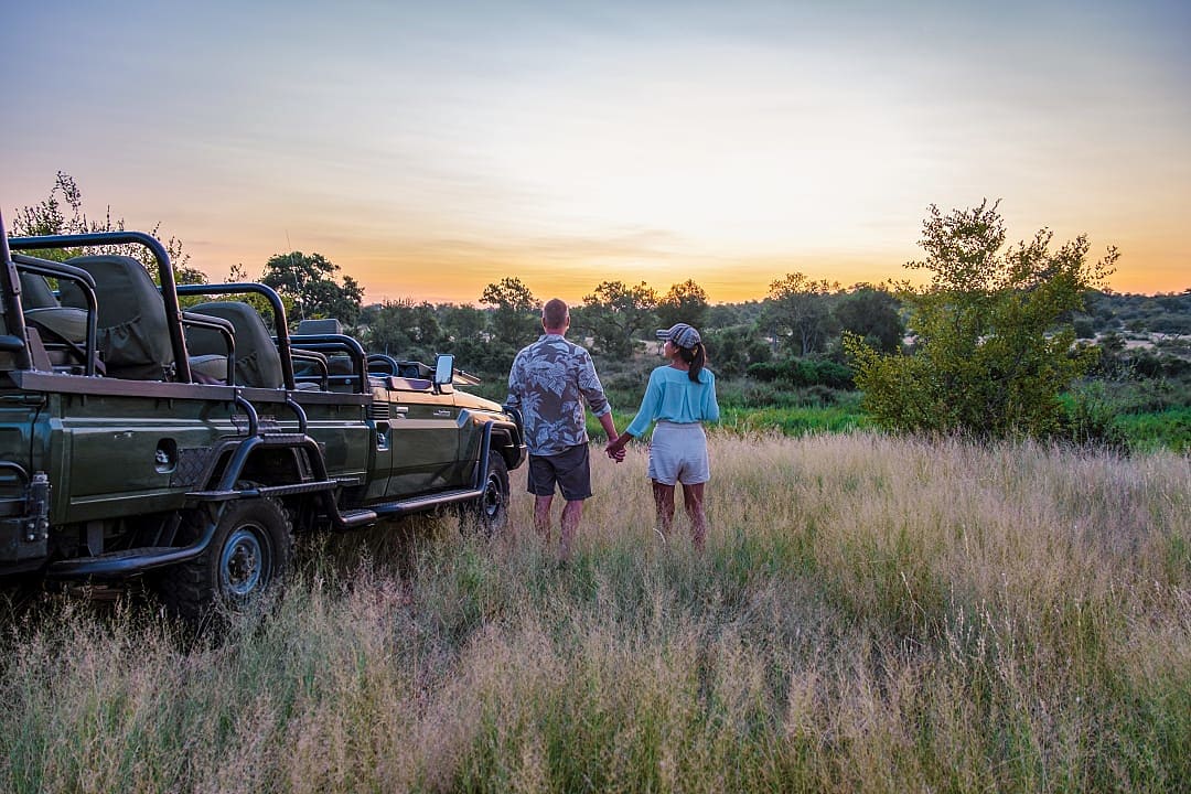 A couple enjoying the sunset, during a safari game drive in the Klaserie Private Nature Reserve.