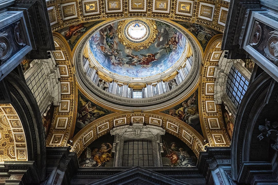 Intricate frescoed dome and ornate ceiling details inside St. Peter’s Basilica in Vatican City.