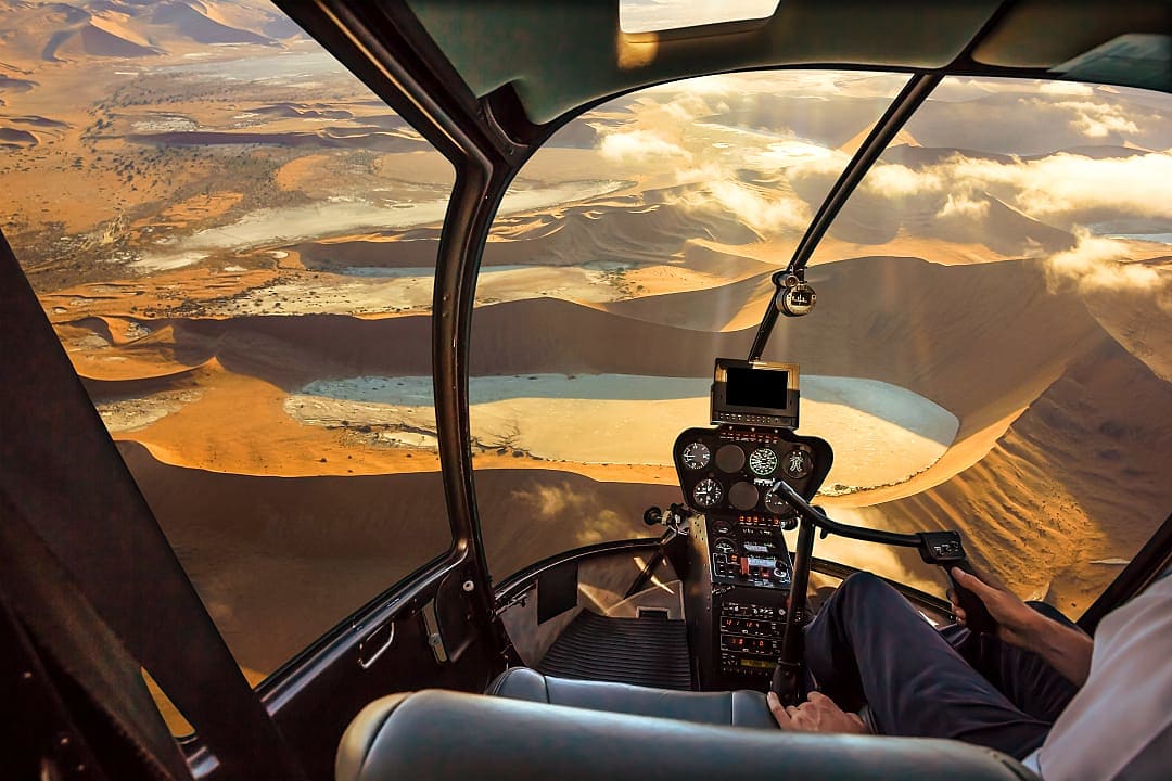 A helicopter soars above Namibia’s stunning Namib-Naukluft sand dunes.