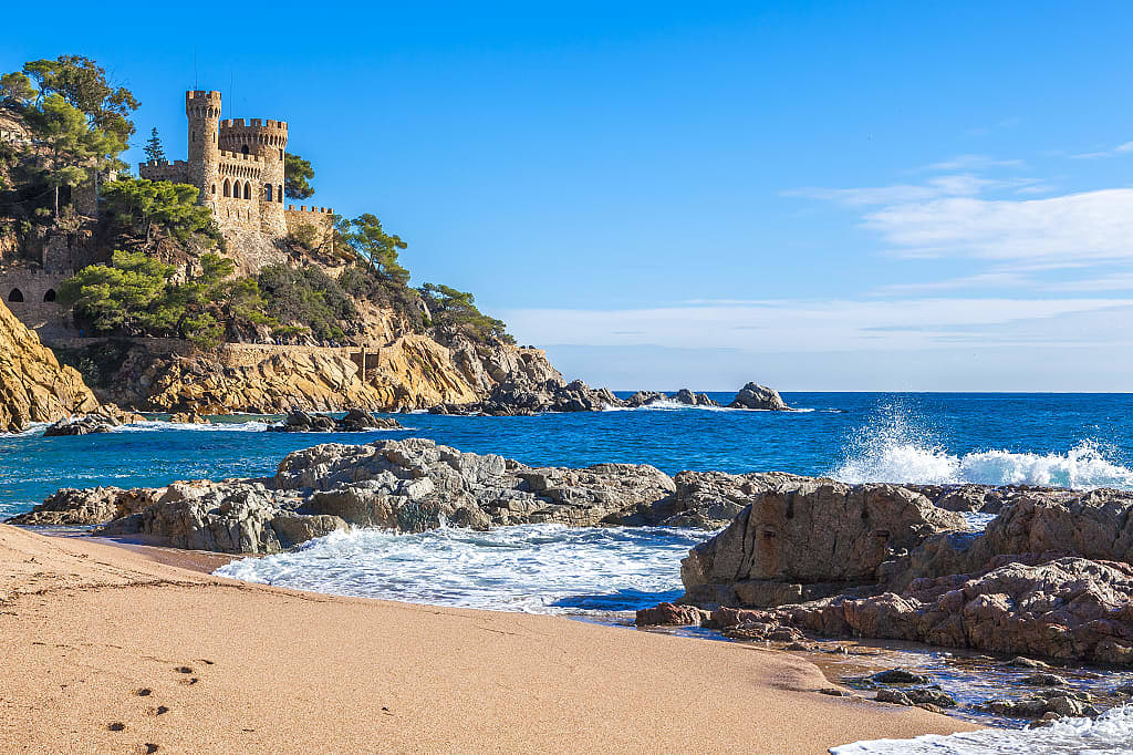 Beach with castle on the rocky cliff in Lloret de Mar on the Costa Brava, Spain