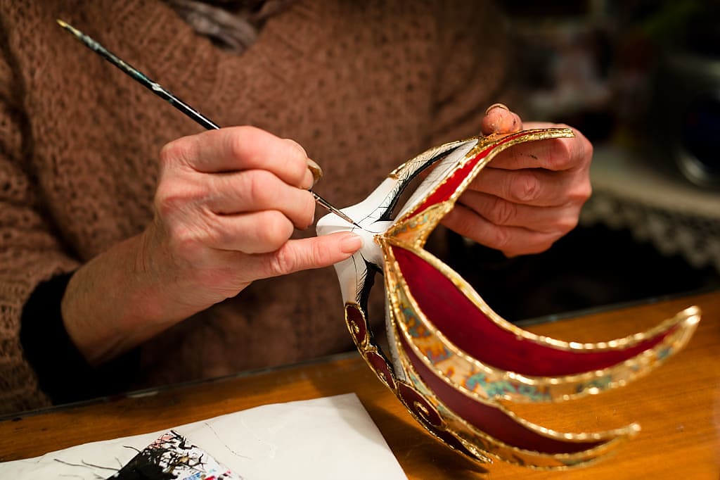 Artist painting carnivale mask in Venice, Italy