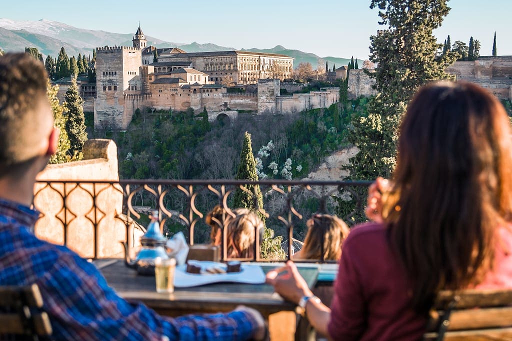 Couple enjoying a view of the Alhambra from a restaurant in Granada, Spain. Photo © Turismo Andaluz