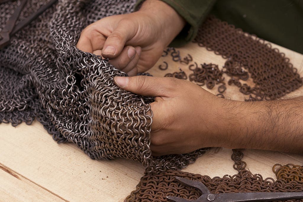 Metal craftsman working on chainmail armor