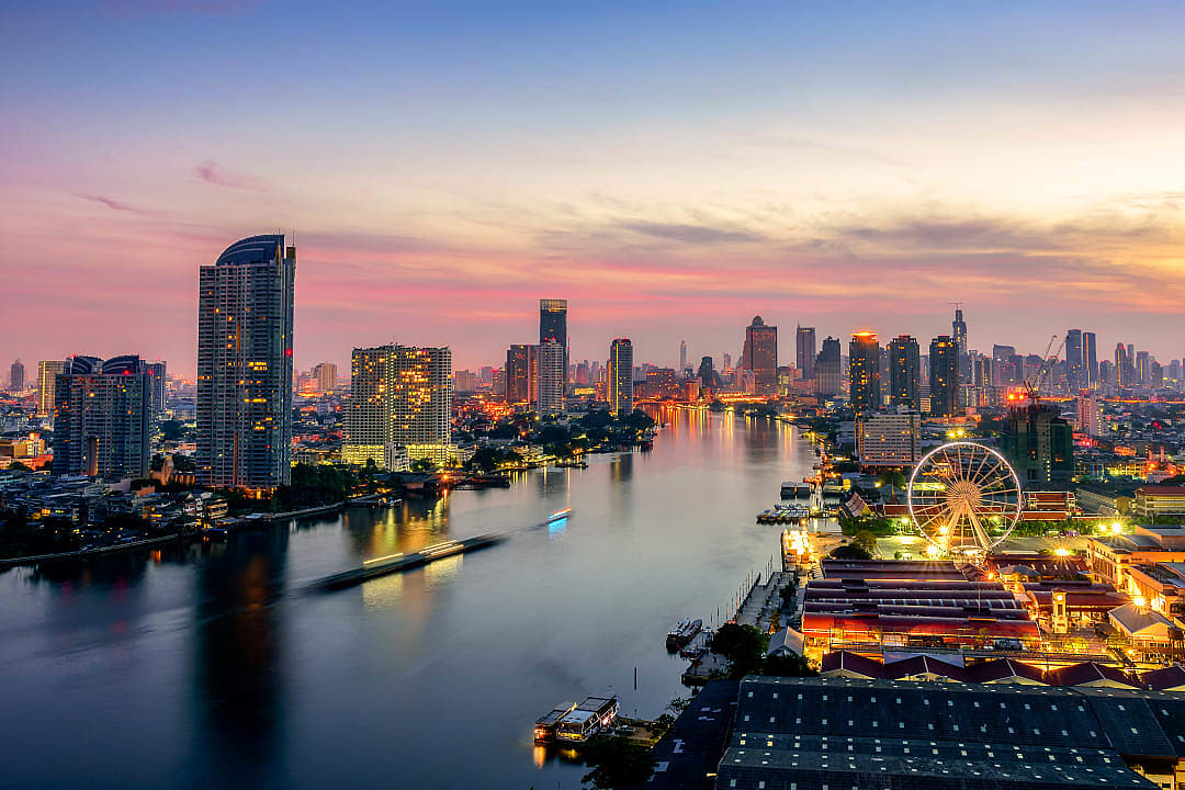 Chao Phraya River and city skyline at sunset in Bangkok.