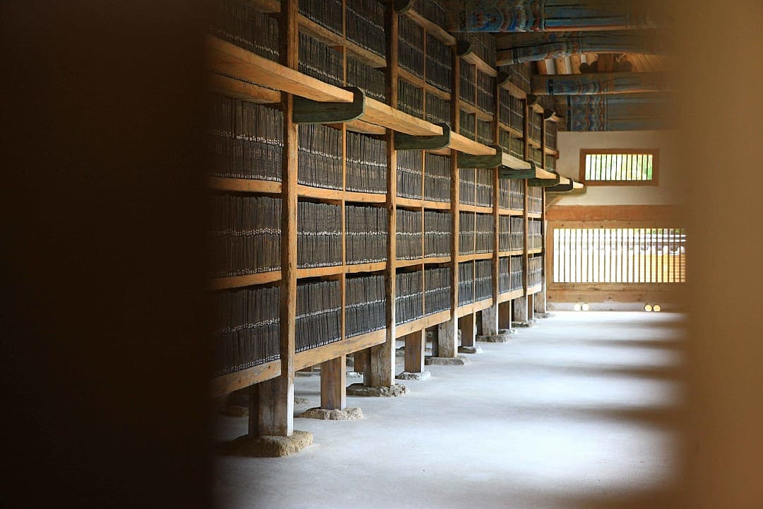 Rows of ancient wooden printing blocks neatly stacked on shelves.