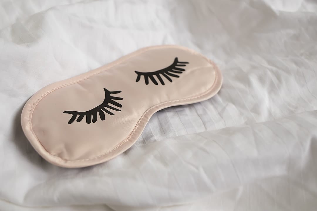 Sleep mask on white bedding