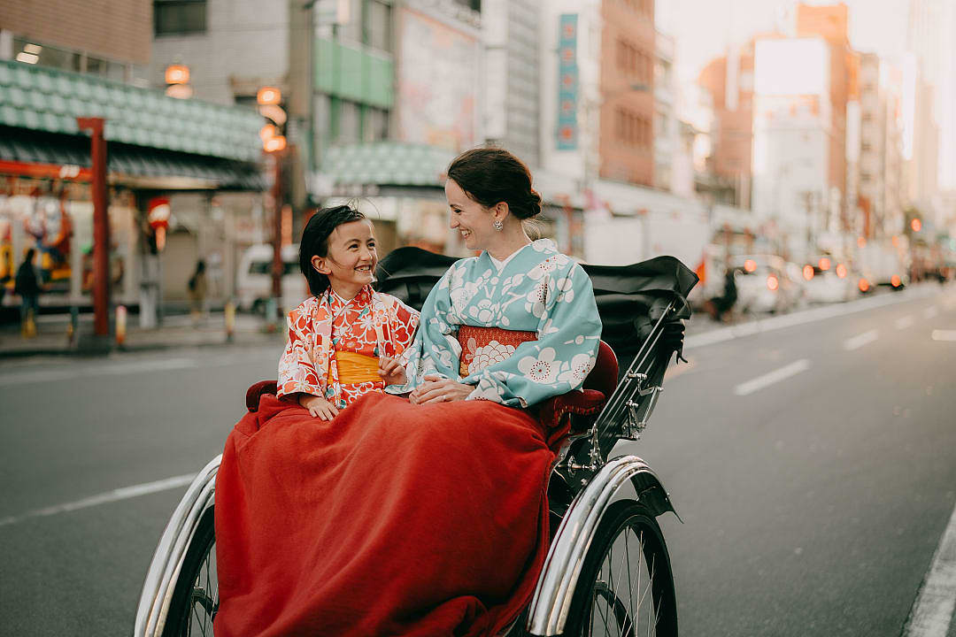 A mother and daughter riding a rickshaw in Tokyo, Japan.