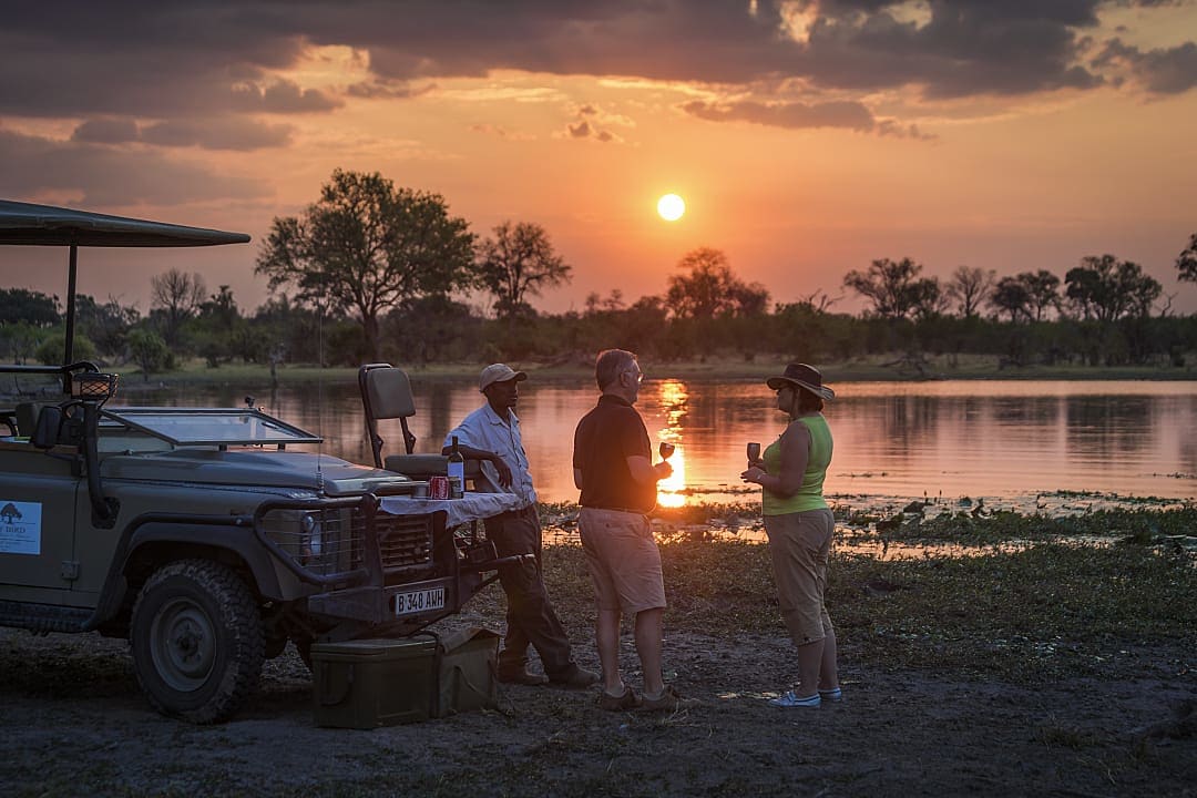 A couple enjoying the sunset during a safari in Botswana.