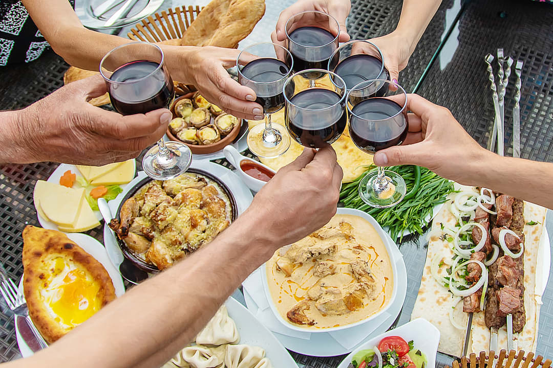 Friends toasting wine over dinner in Georgia