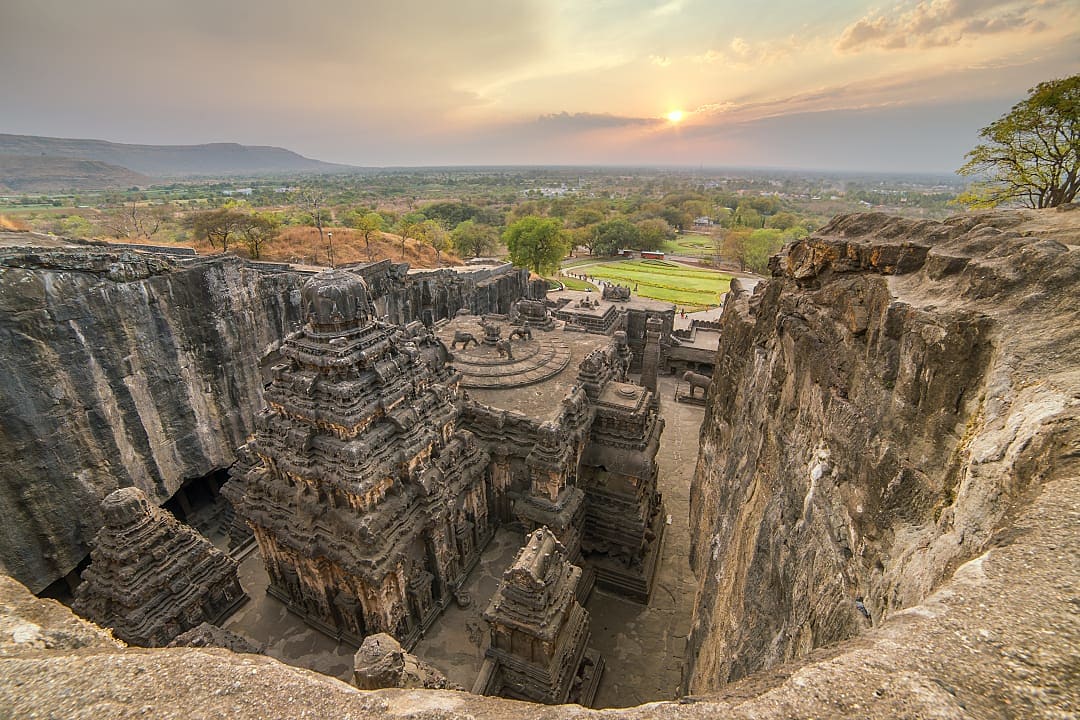 Ancient rock-cut kailasa temple complex with surrounding cliffs at sunrise