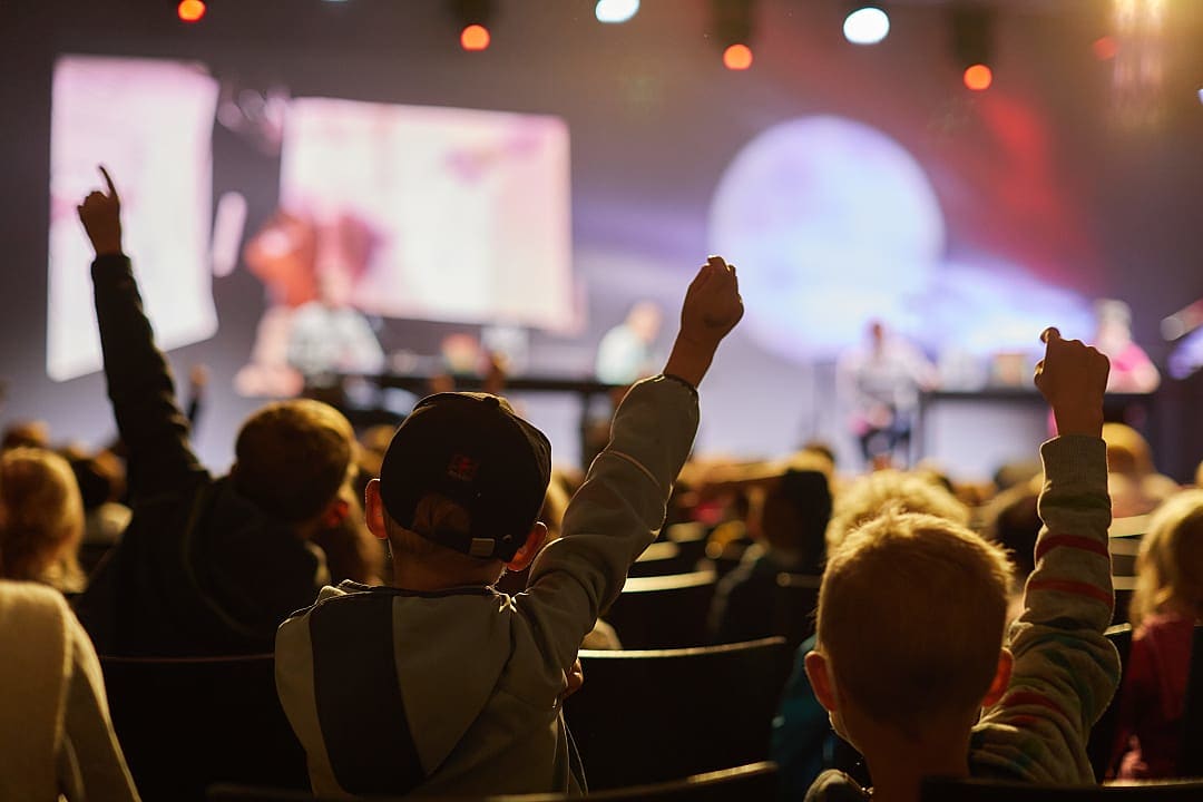 Kids raising their hands during the Youth program reading with Bernard Carvalho at the Berlin International Literature Festival