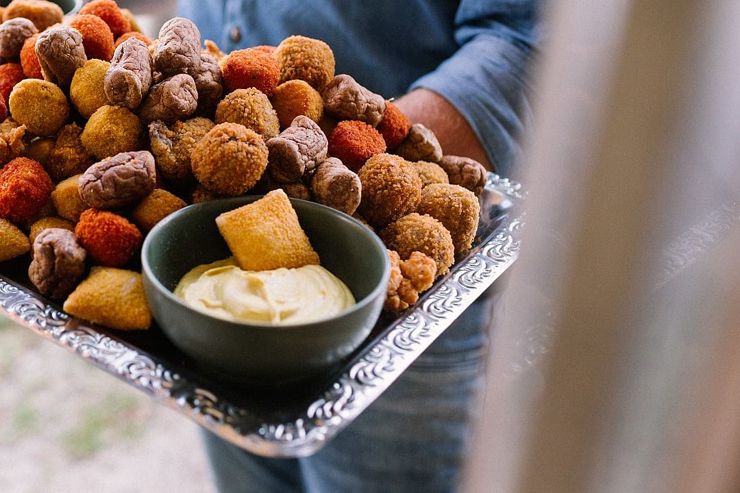 Platter of assorted bitterballen with dipping sauce on a silver tray, served at the Taste of Amsterdam