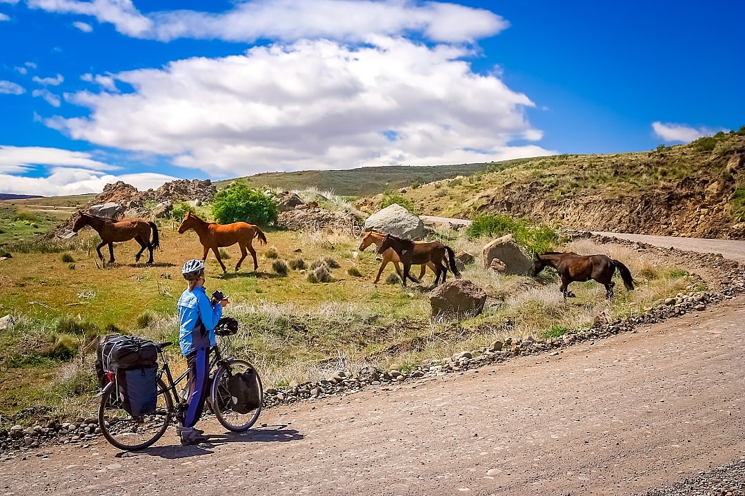 Woman cycling on a remote road in Patagonia, Argentina