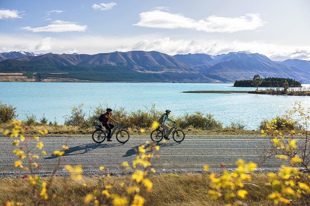 Couple cycling the world-famous Alps 2 Ocean Cycle Trail  (New Zealand's longest continuous cycle trail) at  Lake Tekapo in Canterbury, New Zealand.  Photo courtesy of Miles Holden / New Zealand