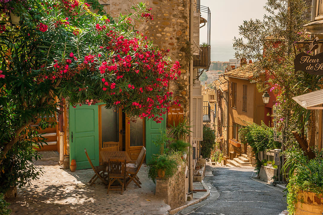 A scenic view of the medieval village of Haut-de-Cagnes in France, featuring stone houses with terracotta roofs, cobblestone streets, and a historic castle