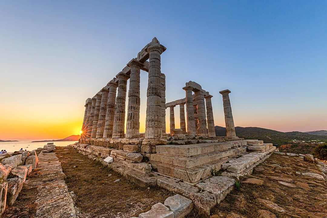 The sunrising on the horizon at the Temple of Poseidon