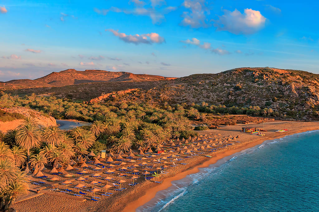 Long strand of beach with umbrellas in Crete