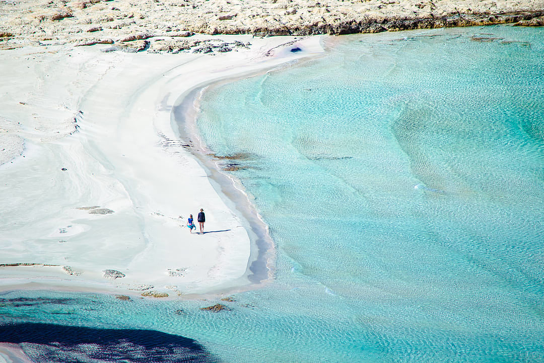 Mother and daughter walking at Balos Beach in Crete, Greece