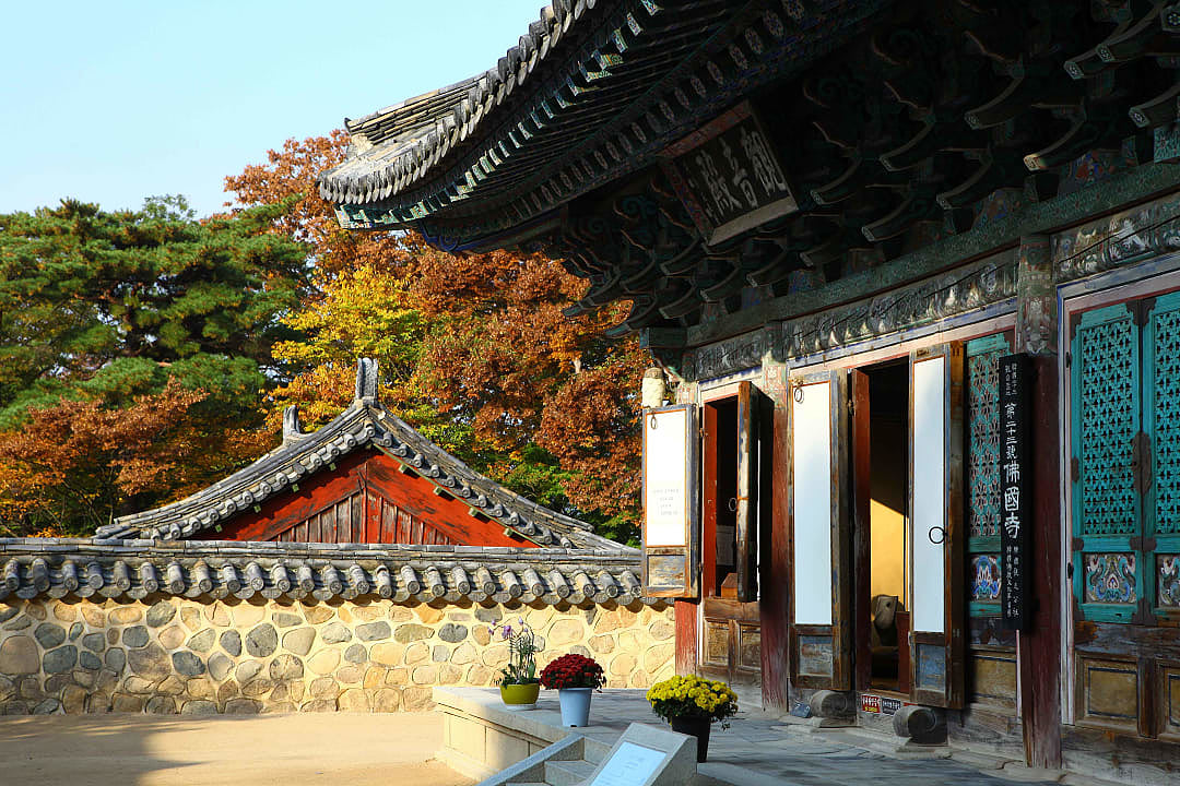 Bulguksa Temple entrance surrounded by autumn foliage in Gyeongju, South Korea.