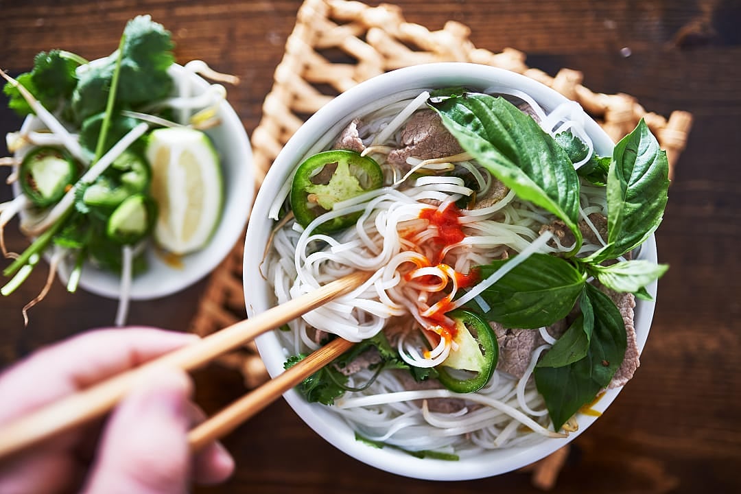 Tradition Vietnamese pho dish with spicy sriracha sauce.