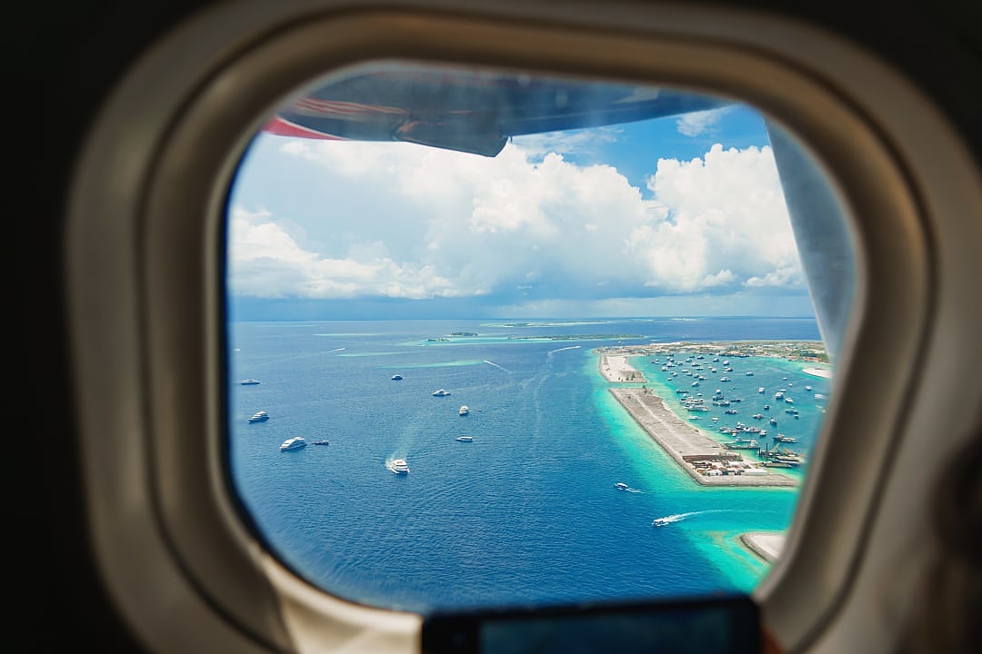 Aerial view reveals vibrant Malé Harbor surrounded by turquoise waters.