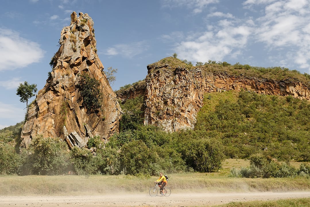 A woman cycling through Kenya's Hell's Gate.