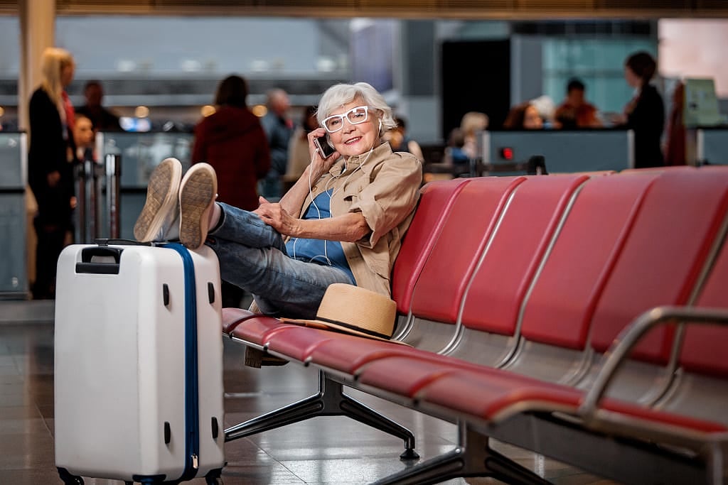Senior female traveler with luggage at the airport